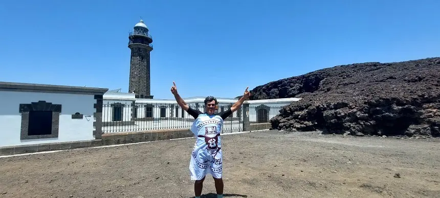 Imagen de Nacho Herrero en el meridiano cero de El Hierro con la bandera de la asociación DalecandELA.