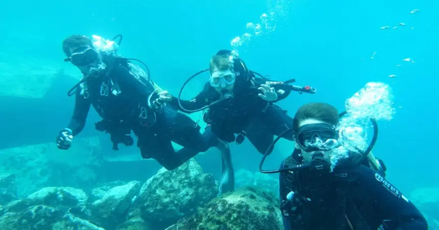 Imagen de tres de los jovenes participantes en la jornada de buceo.