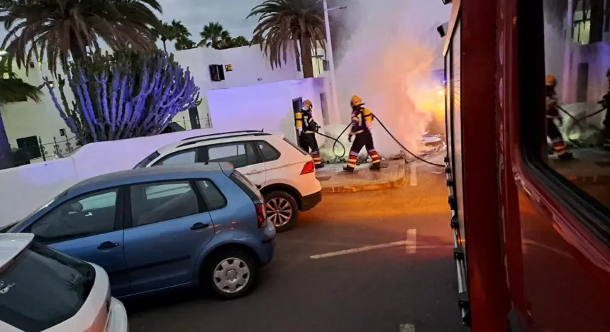 Imagen de los bomberos extinguiendo un fuego localizado en unos contenedores.