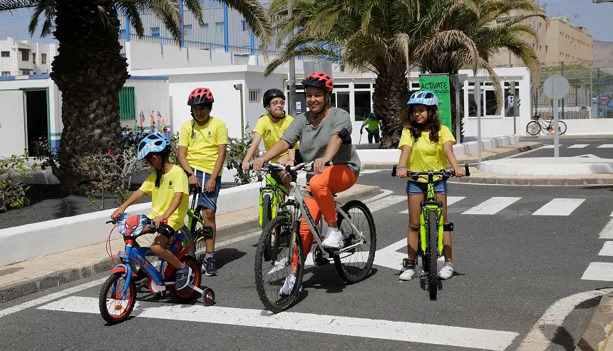 Imagen de Myriam Barros junto a varios niños durante el taller Actívate Biciandando.