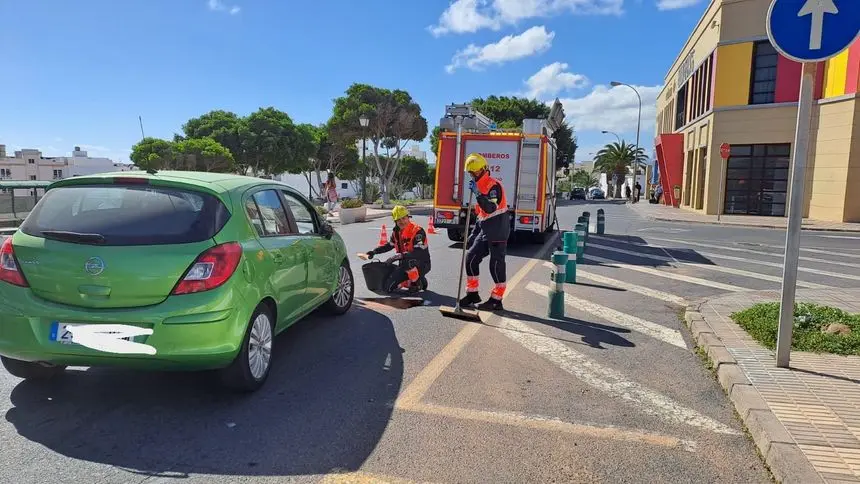 Los bomberos limpiando la mancha de aceite en la Vía Medular.