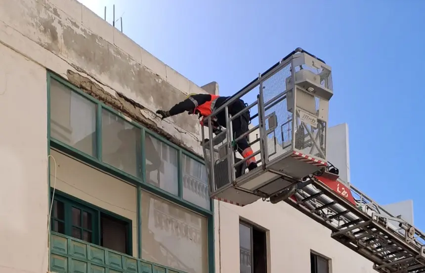 Imagen de los bomberos comprobando el estado de la fachada dañada.