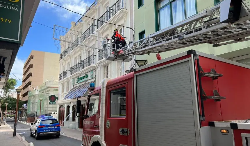 Imagen de los bomberos recogiendo uno de los cables caídos en la calle Fajardo