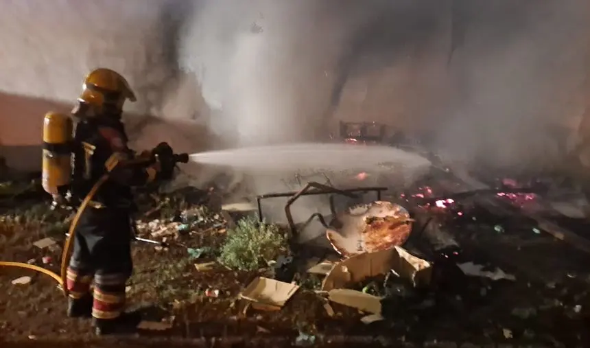 Imagen de uno de los bomberos sofocando un incendio de basura abandonada