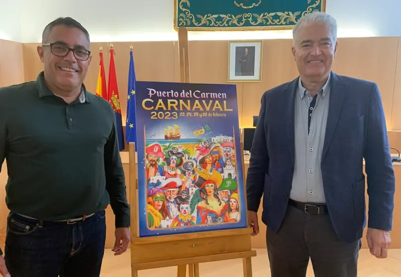 Sergio García y José Juan Cruz junto al cartel del carnaval de Puerto del Carmen 2023.