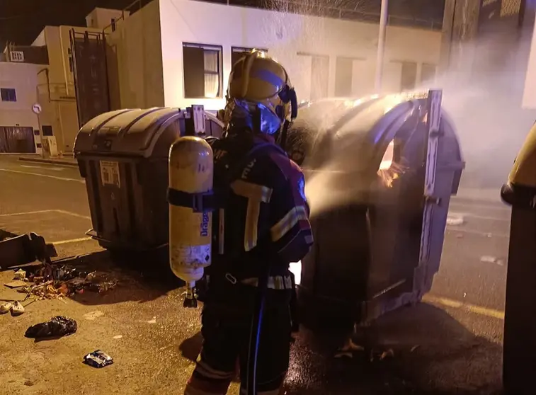 Imagen de los bomberos realizando las labores de extinción del fuego en el contenedor.