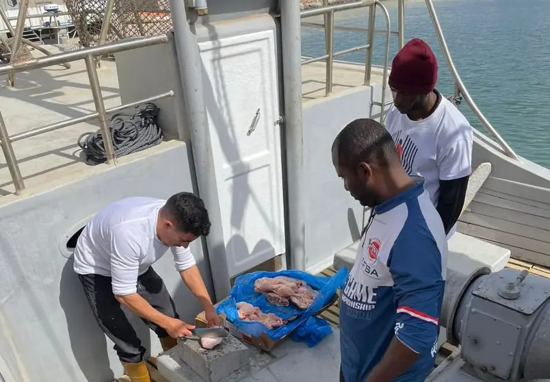 Imagen de uno de los pescadores de La Santa mostrando la forma de alimentar a las gambas.