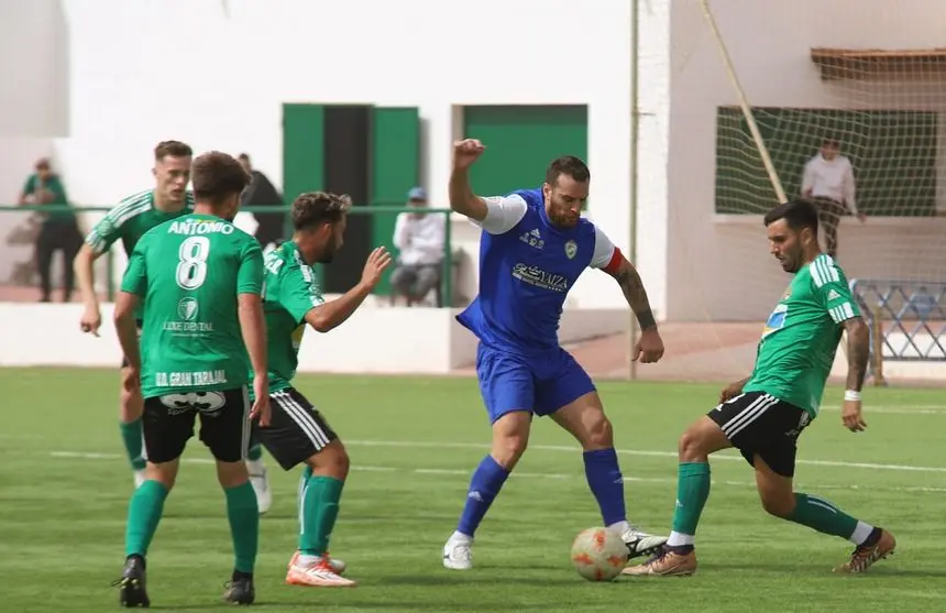 Jugadores del Gran Tarajal rodeando a un jugador del Yaiza