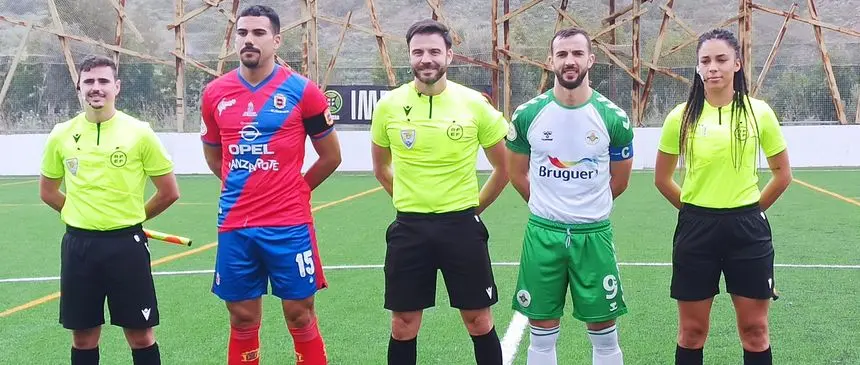 Imagen de los jugadores de los dos equipos con el trío arbitral