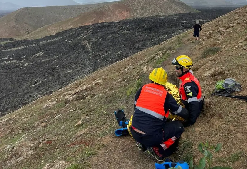 Imagen de los bomberos con la senderista accidentada