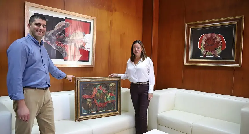 Benjamin Perdomo junto a un cuadro adquirido y María Dolores Corujo.