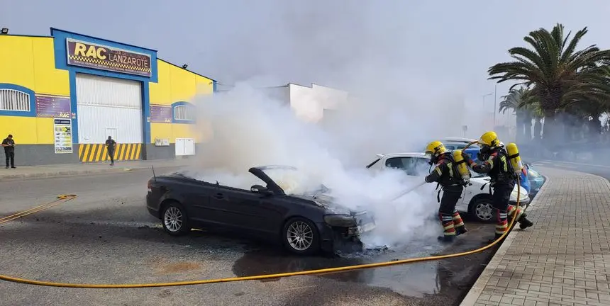 Imagen del momento de la actuación de los bomberos para apagar el fuego del coche.