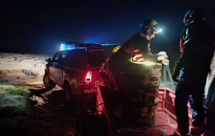 Instante en el que los bomberos amarran el bidón para su traslado
