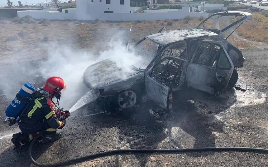 Bombero sofocando el fuego en el vehículo.