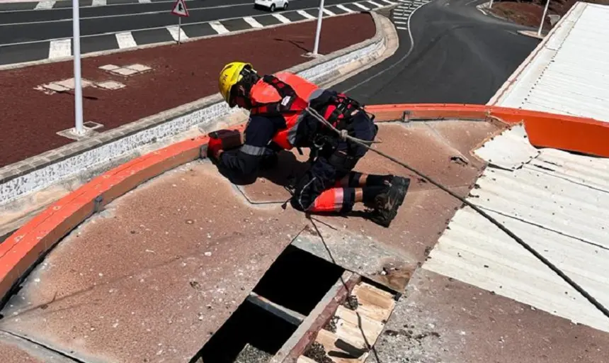 Bombero reparando el techo de una gasolinera.