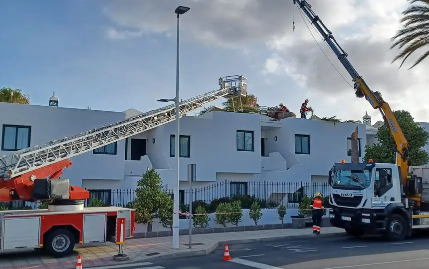 Imagen de los bomberos trabajando sobre el techo de los apartamentos