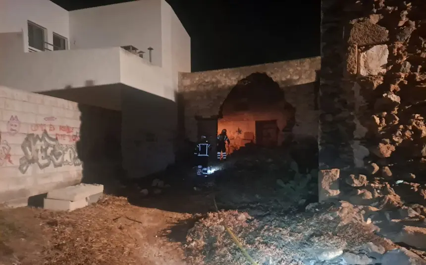 Bomberos extinguiendo el fuego en la casa abandonada.