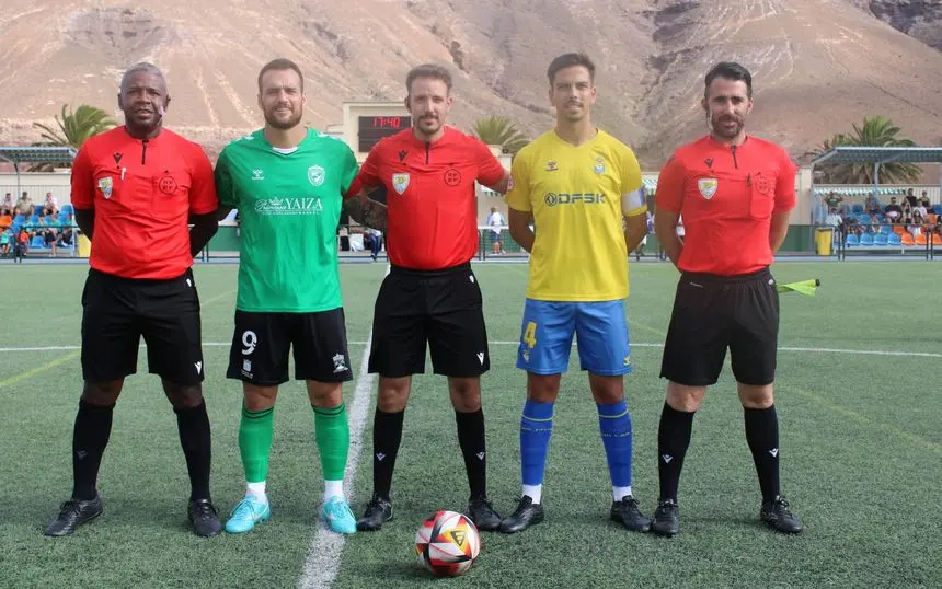 Imagen de los capitanes de los dos equipos con el trío arbitral
