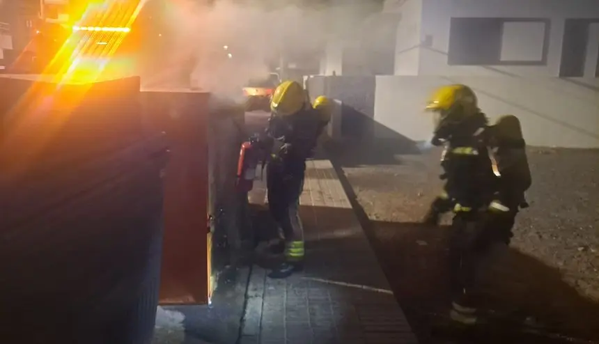 Momento de la actuación de los bomberos para sofocar el fuego del contenedor