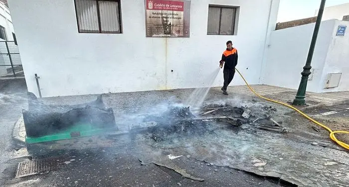 Un operario limpia tras el incendio de los contenedores en la plaza de San Roque.