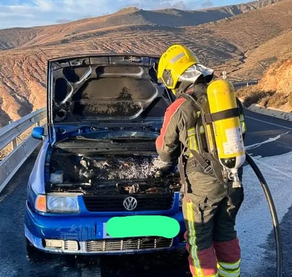 Imagen del bombero sofocando el fuego del motor