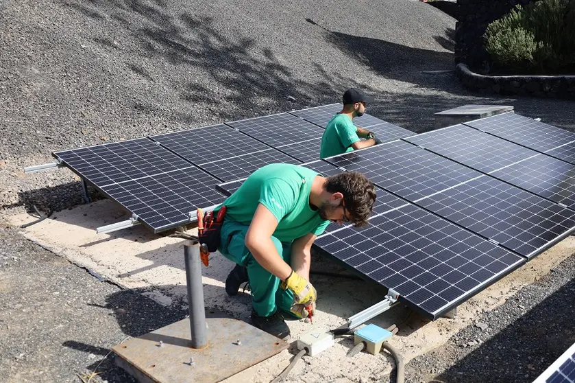 Alumnos de la escuela taller revisando la instalación de placas solares