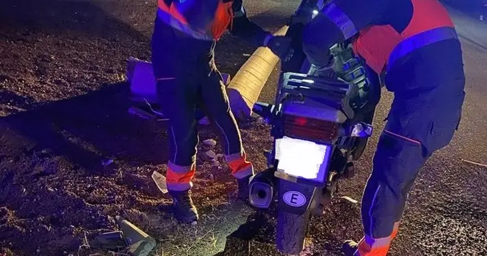 Momento en el que los bomberos retiraban la moto de la calzada.