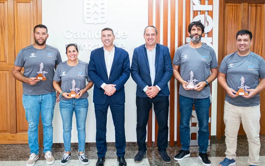 El presidente del Cabildo y el consejero de Deportes con la tripulación del barco ganador.