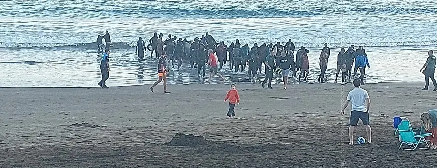 Llegada de los inmigrantes a la playa de La Garita mientras se encontraban varias personas disfrutando de la tarde.