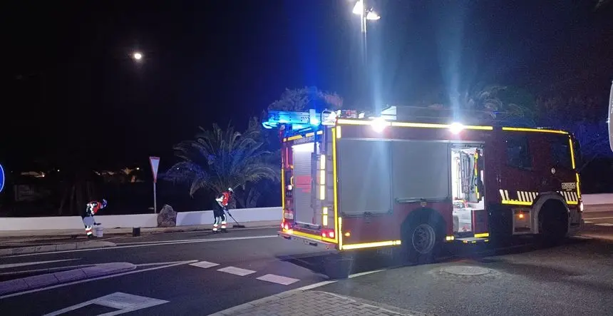 Momento en el que los bomberos limpian la calzada tras el accidente
