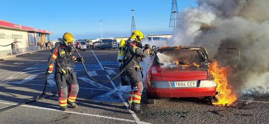 Momento de la llegada de los bomberos para apagar el fuego del vehículo