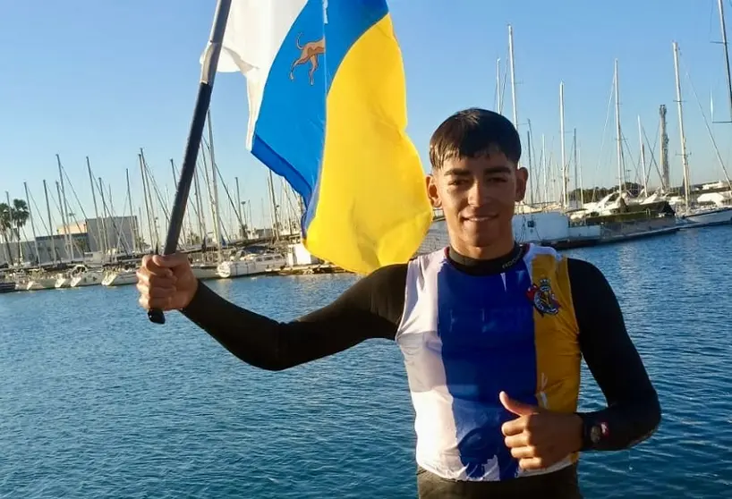 Alonso Pérez celebrando su triunfo con la bandera canaria.