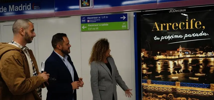 El alcalde de Arrecife y la concejal de Turismo en Madrid viendo el anuncio del metro.
