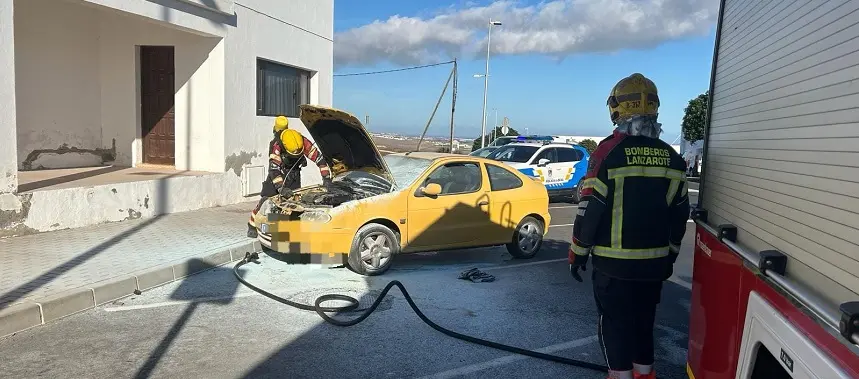 Bomberos del Consorcio de Seguridad y Emergencias sofocando el fuego localizado en el motor del coche.