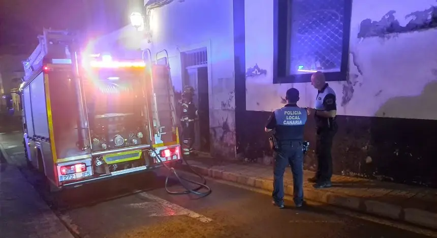 Imagen del momento de la actuación de los bomberos en la vivienda en presencia de agentes de la Policía Local