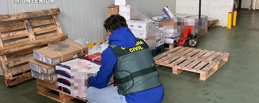 Agente de la Guardia Civil junto a la mercancía robada.