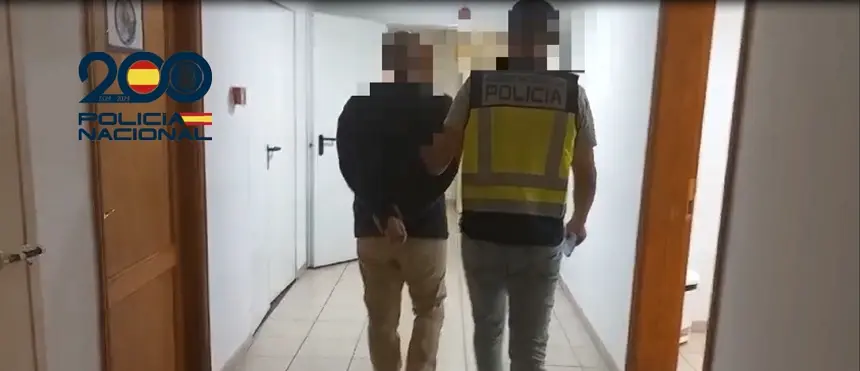Agente de la Policía Nacional acompañando al detenido.