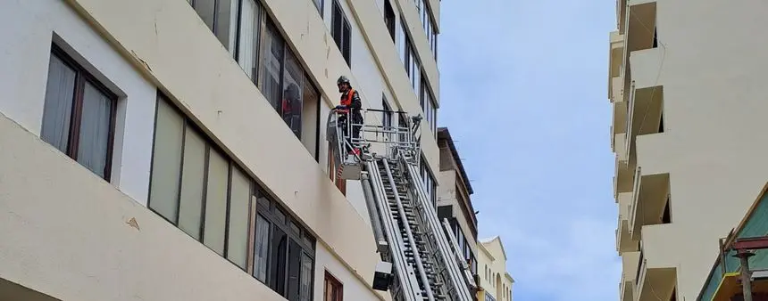 Imagen de uno de los bomberos accediendo a la vivienda por la ventana