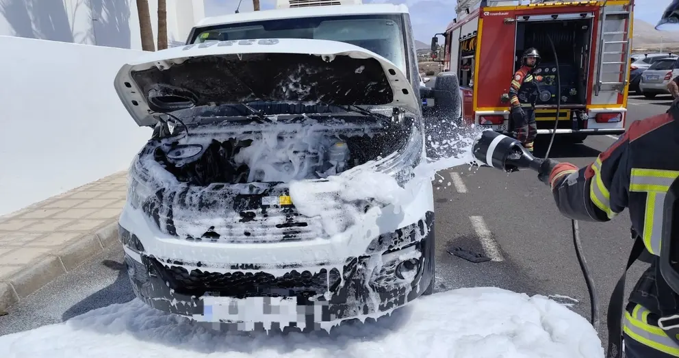 Bomberos del Consorcio apagando el fuego localizado en el motor del vehículo lanzando espuma.