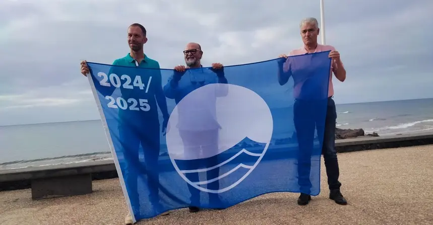 Representante del Ayuntamiento de Tías junto a la bandera azul.