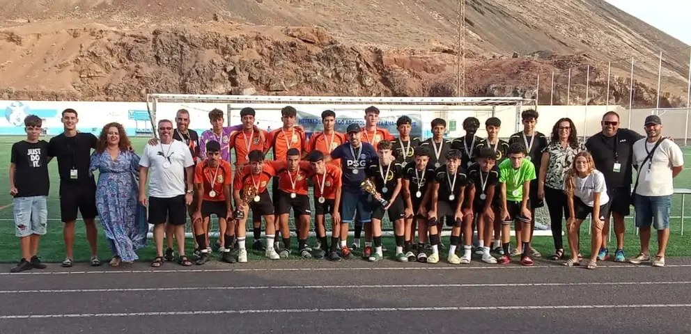 Los dos equipos que llegaron a la final con los trofeos y los organizadores de la prueba.