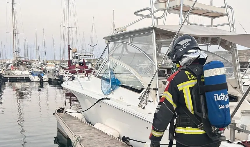 Imagen de un bombero junto a la embarcación afectada.