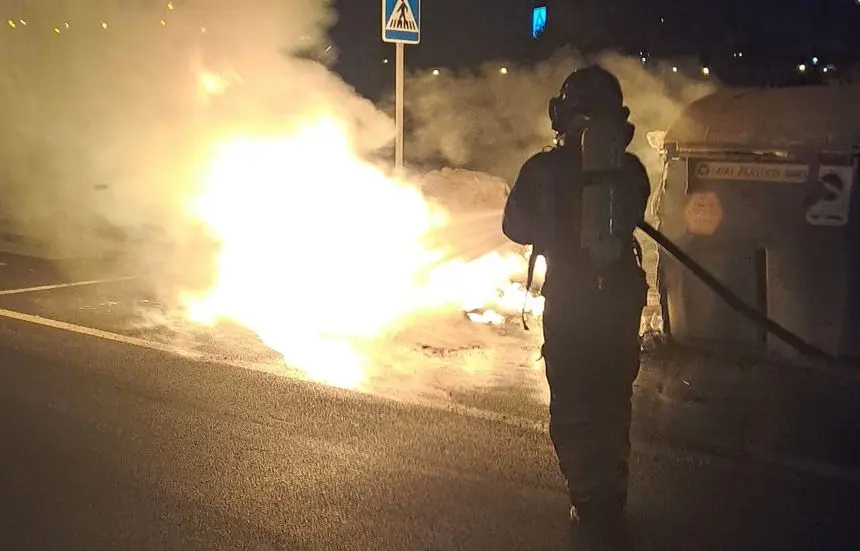 Un bombero extingue el fuego de los contenedores en Arrecife.