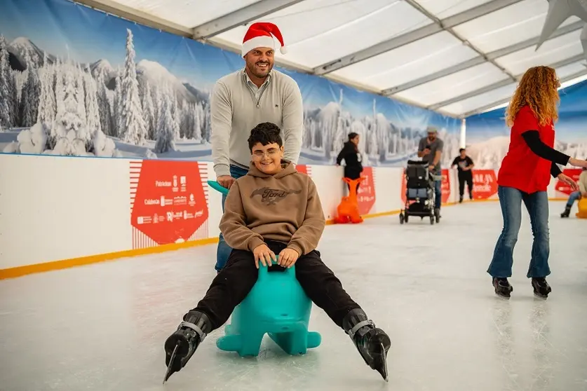 Yonathan de León junto a uno de los niños en la pista de hielo durante la jornada inclusiva de Navilan.