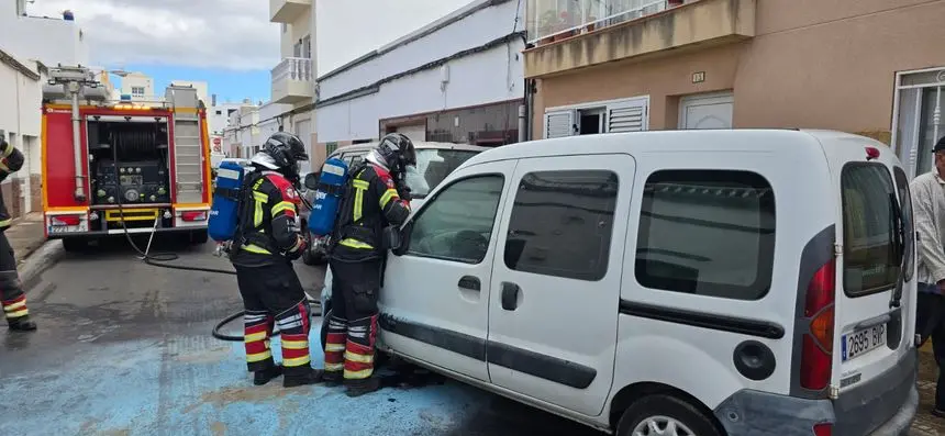 Imagen del vehículo en plena calle siendo apagado por los bomberos