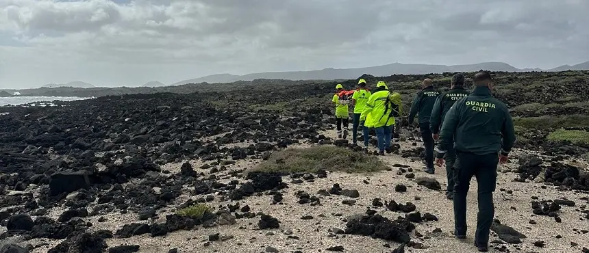 Operarios de EMERLAN junto a la Guardia Civil portando el cuerpo del fallecido.