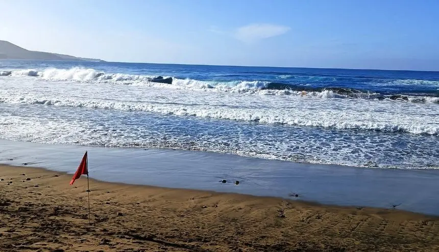 Imagen de una playa de Canarias con bandera roja
