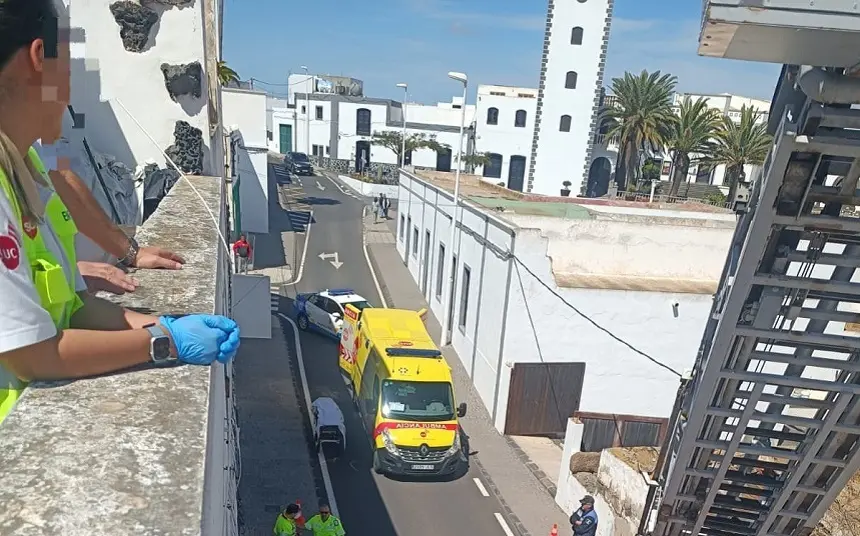 Personal del SUC colaborando con los bomberos en la azotea para bajar a la persona herida en la escalera.