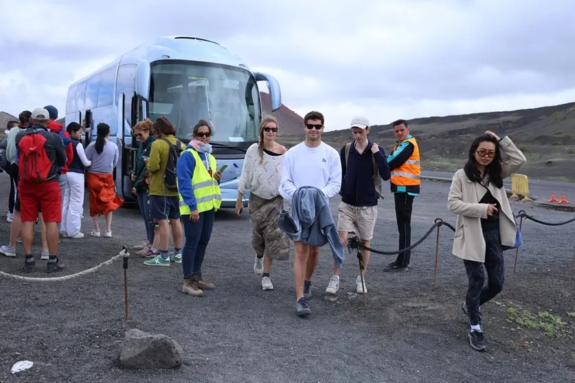 Visitantes bajando en el volcán del Cuervo de la guagua Lanzadera.