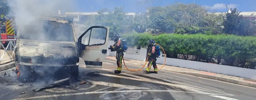 Bomberos sofocando el fuego localizado en la cabina del camión.